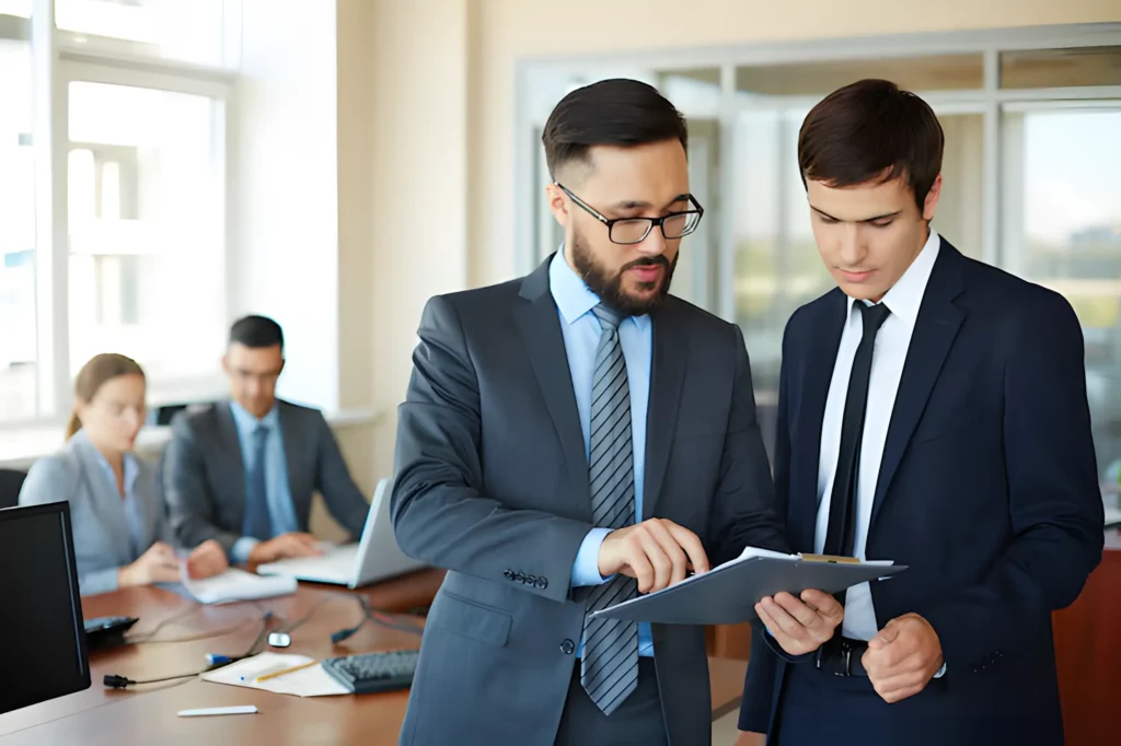 Two businessmen reviewing documents on digital tablet