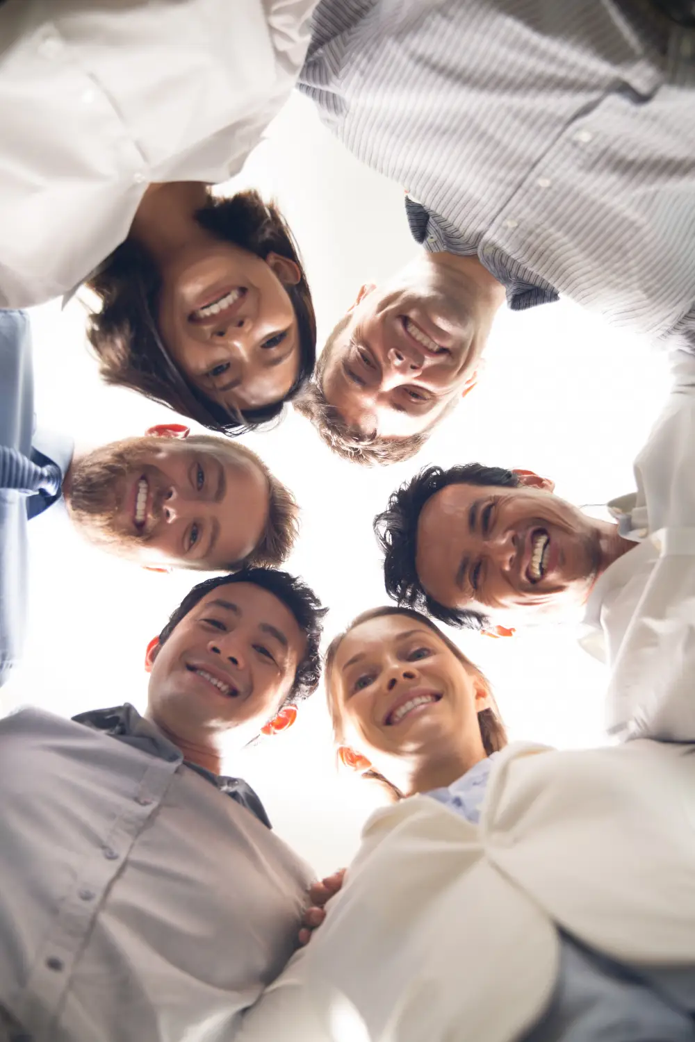 Group of diverse coworkers smiling in team huddle