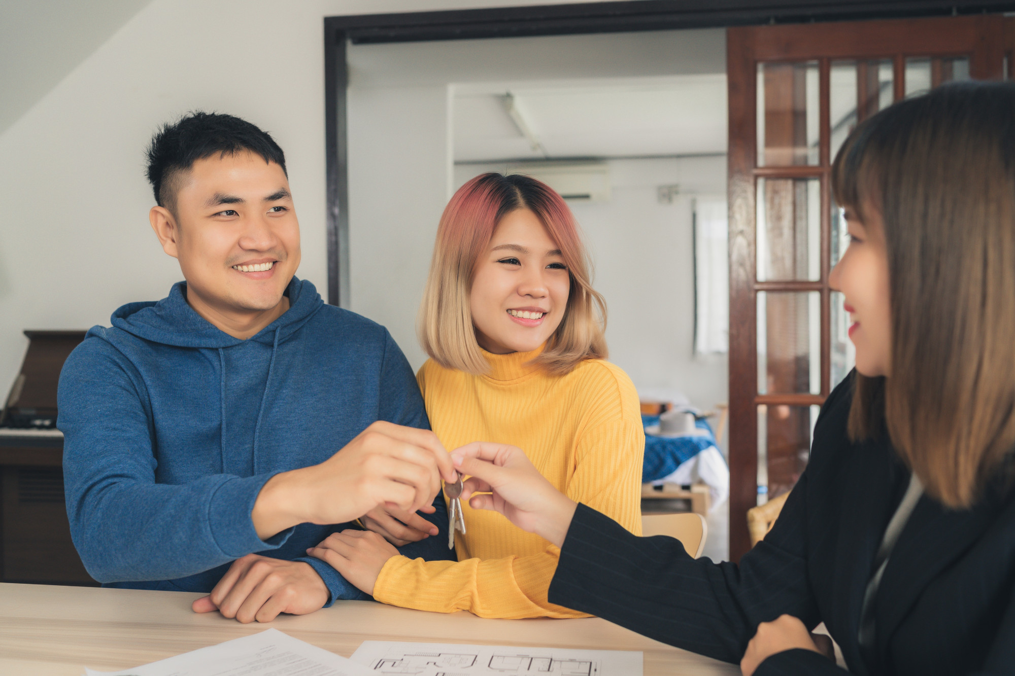 Real estate agent handing house keys to smiling couple
